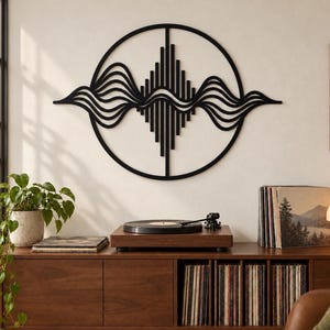 May include: A black circular wall art piece featuring a central vertical bar design intersected by horizontal flowing wave patterns. The structure is composed of thin, interconnected lines forming a symmetrical geometric shape that spans horizontally.