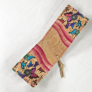 Cartera con cierre magnético y presilla de sujeción.