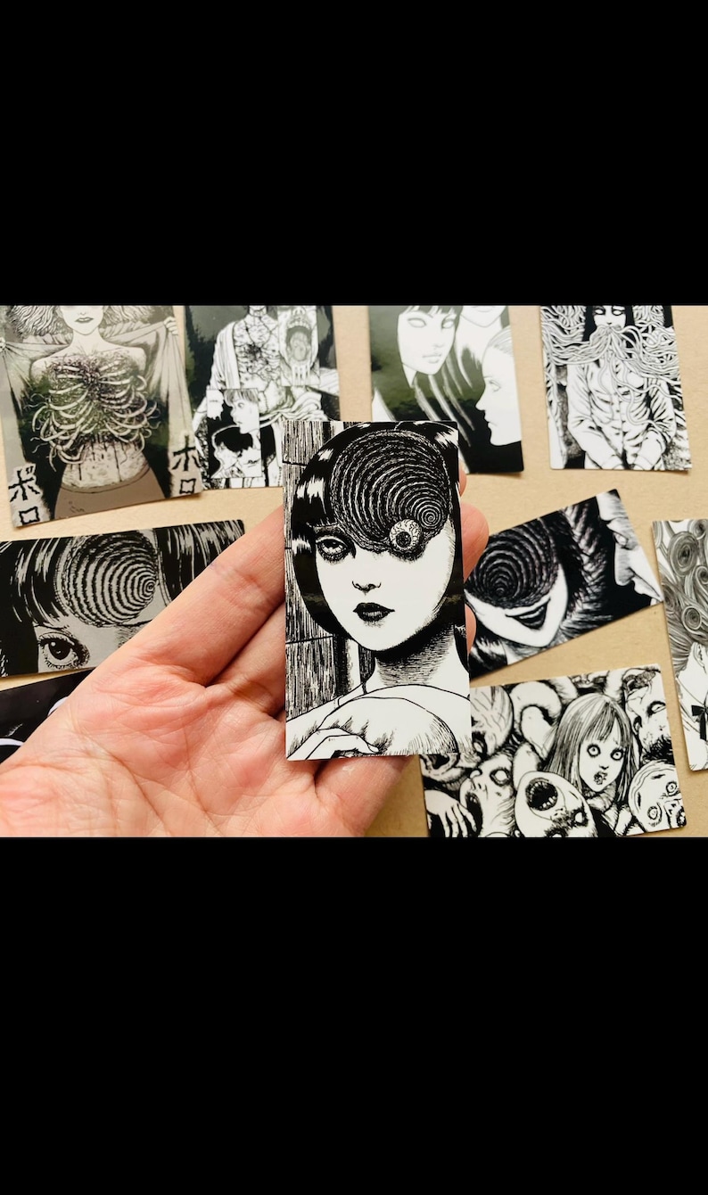 Może przedstawiać: Zestaw czarno-białych naklejek przedstawiających postać z okiem w kształcie spirali i innymi motywami grozy. Naklejki są wydrukowane na białym papierze i mają błyszczące wykończenie.