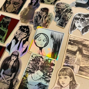 Może przedstawiać: Zbi&oacute;r czarno-białych naklejek o tematyce horroru przedstawiających r&oacute;żne postacie i sceny. Naklejki są wydrukowane na błyszczącym papierze i mają holograficzne wykończenie. Niekt&oacute;re naklejki zawierają tekst w języku japońskim.