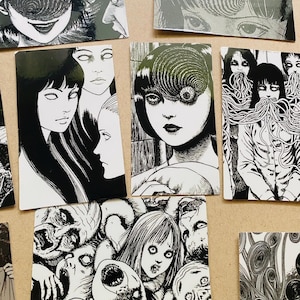 Może przedstawiać: Zestaw dziesięciu czarno-białych naklejek o tematyce horroru przedstawiających postacie z mangi Uzumaki. Naklejki przedstawiają r&oacute;żne postacie, w tym kobietę ze spiralą w oku, kobietę z długimi włosami i grupę ludzi z mackami.