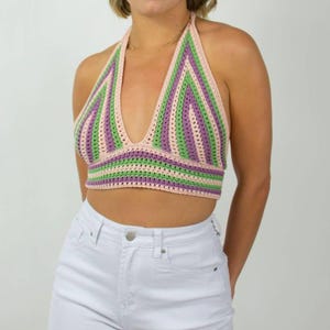 May include: A striped crochet halter top with pink, green and purple stripes. The top is sleeveless and has a deep V-neckline.