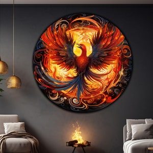 May include: A circular wall art piece featuring a fiery phoenix with red, orange, and yellow flames against a black background. The phoenix has blue and black feathers and is surrounded by swirling patterns.
