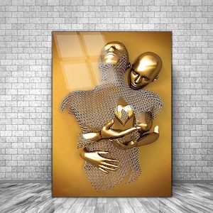 May include: A gold-toned sculpture of two figures embracing. The figures are made of chainmail and have a heart-shaped object in the center of their chests.