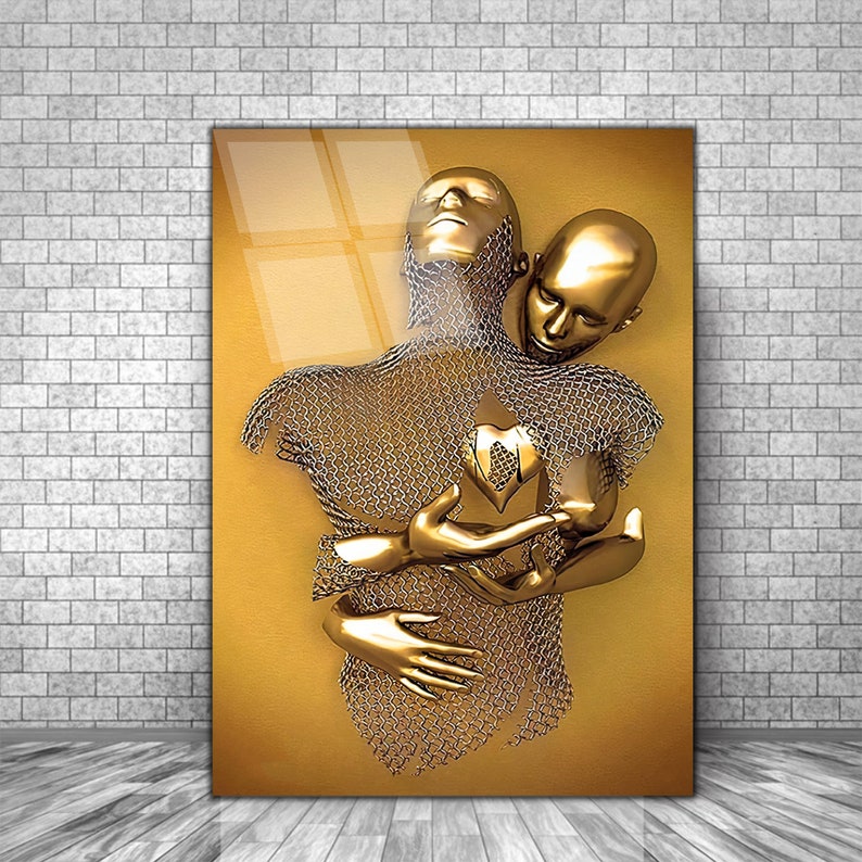 May include: A gold-toned sculpture of two figures embracing. The figures are made of chainmail and have a heart-shaped object in the center of their chests.