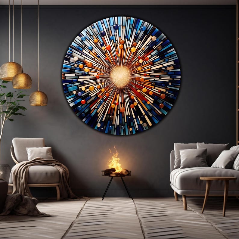 May include: A circular abstract art piece with a burst of color and light. The artwork is made of glass and features a variety of colors, including blue, orange, and yellow. The artwork is hanging on a dark gray wall in a modern living room.