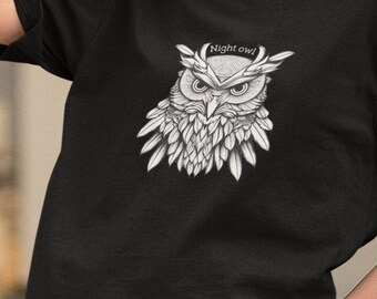 Op de afbeelding: Een zwart T-shirt met een witte afbeelding van een uil met de tekst "Night owl" erboven.