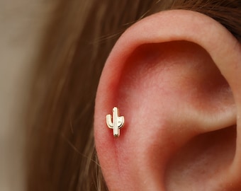May include: A gold cactus-shaped stud earring for a helix piercing.