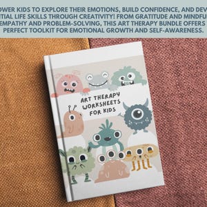 May include: A white book with a colorful cover featuring cartoon monsters. The book title is "Art Therapy Worksheets for Kids".