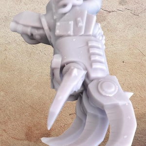 Puede incluir: Una garra mecánica gris claro con cuchillas afiladas y curvas y blindaje detallado. La garra presenta un diseño complejo con articulaciones y una superficie texturizada, lo que sugiere un tema futurista o de ciencia ficción.