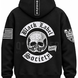 Puede incluir: Una sudadera negra con capucha que presenta un gran gráfico blanco en la espalda con una calavera, el texto Black Label Society y SDMF. La capucha muestra la palabra BERSERKER verticalmente. Un parche de bandera está en la manga derecha y un escudo a la izquierda.
