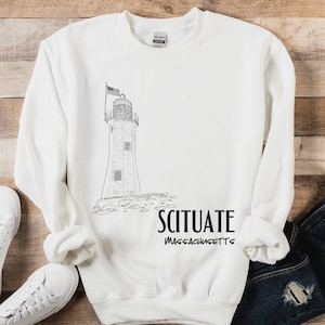 May include: White sweatshirt with a black and white illustration of a lighthouse and the text "SCITUATE MASSACHUSETTS".