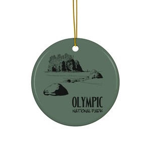 May include: A green ceramic ornament with a black and white illustration of a rocky coastline and the text "Olympic National Park".
