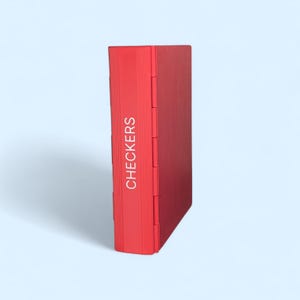 May include: A red checkers game set with the word "CHECKERS" printed vertically on the spine. The game set is rectangular and appears to be made of a solid material. The game set is on a light blue background.
