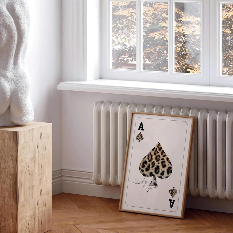 May include: A framed print of an ace of spades playing card with a leopard print design. The text "lucky you" is printed below the card.