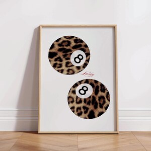 May include: A framed print with two 8-ball pool balls. The balls are covered in a leopard print pattern. The text "Lucky" is printed in red below the top ball.