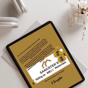 May include: A tablet computer displaying a gold background with the text "Sangster's Selling on eBay Masterclass How to go from $100 to $100,000 J. Sangster". The tablet is on a white surface with a pair of white headphones and a dried plant in a white vase.