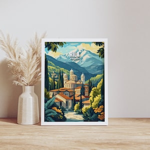 May include: A vintage travel poster featuring a colorful illustration of Rila Monastery in Bulgaria. The poster has a blue and green mountain range in the background with a white peak. The monastery is in the foreground with a path leading to it. The text "RILA" and "BULGARIA" is printed in white on the poster.