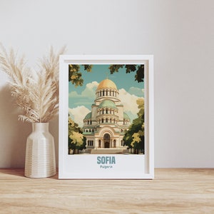 May include: A white framed print with a vintage travel poster design featuring a colorful illustration of the Alexander Nevsky Cathedral in Sofia, Bulgaria. The text "SOFIA Bulgaria" is printed below the illustration.