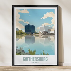 Könnte beinhalten: Ein gerahmter Kunstdruck mit einer stilisierten Illustration von Gaithersburg, Maryland. Das Kunstwerk zeigt moderne Gebäude, die sich in einem See unter blauem Himmel mit Wolken spiegeln. Das Wort "Gaithersburg" ist unten aufgedruckt.