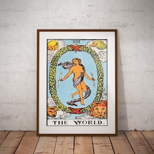 May include: Framed tarot card print featuring "The World" card. The artwork depicts a nude figure holding two wands, encircled by a laurel wreath. The card has a blue background and is framed in a brown wooden frame. The text "THE WORLD" is at the bottom.