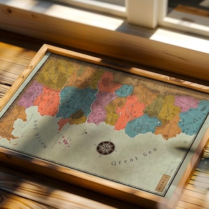 May include: A framed fantasy map featuring colourful land regions, mountain ranges, and labelled bodies of water including the North Sea and Great Sea. The map includes a compass rose, various place names like Nittgaard, and a decorative border.