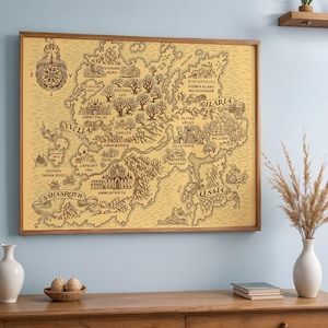 May include: A framed map print with a vintage aesthetic. The map, in shades of brown and tan, depicts a fantasy world with detailed illustrations of cities, forests, and geographical features. The wooden frame adds a classic touch to the artwork.