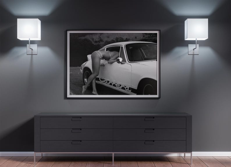 K&ouml;nnte beinhalten: Schwarzwei&szlig;foto einer Frau, die sich an ein wei&szlig;es klassisches Auto lehnt. Das Auto hat einen schwarzen Streifen an der Seite mit dem Wort "Carrera" darauf.