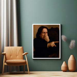 Könnte beinhalten: Ein gerahmtes Porträt eines Mannes in schwarzer Kleidung, mit langen dunklen Haaren, der sich die Nase zuhält und zeigt. Das Porträt wird an einer türkisgrünen Wand neben einem Holzstuhl und dekorativen Vasen ausgestellt.