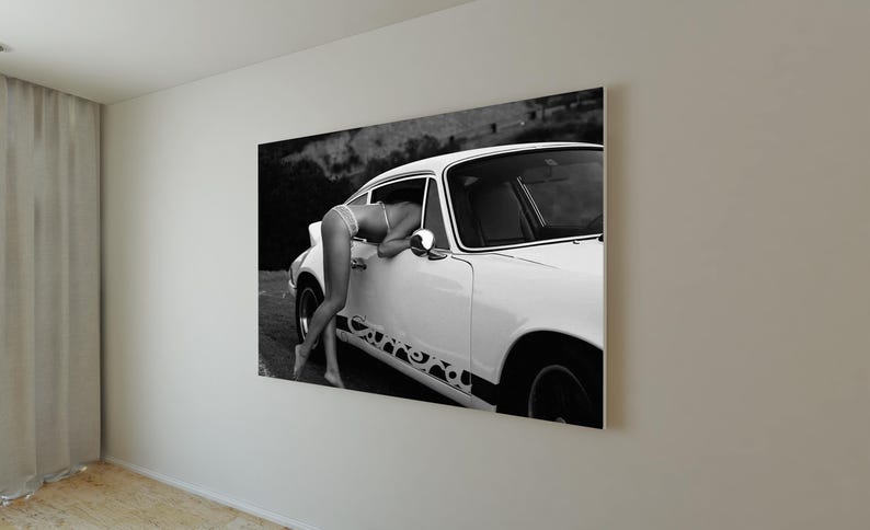 K&ouml;nnte beinhalten: Ein Schwarzwei&szlig;foto einer Frau im Bikini, die sich in ein wei&szlig;es Vintage-Sportwagen lehnt. Das Auto hat einen schwarzen Rennstreifen und die Frau schaut in das Auto.
