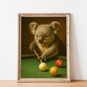 Könnte beinhalten: Gerahmter Druck mit einem Koala beim Billardspiel. Der Koala hält einen Billardqueue und zielt auf eine weiße Kugel. Zwei weitere Kugeln, eine rote und eine gelbe, liegen auf dem grünen Filztisch. Der Druck hat eine Vintage-Ästhetik.