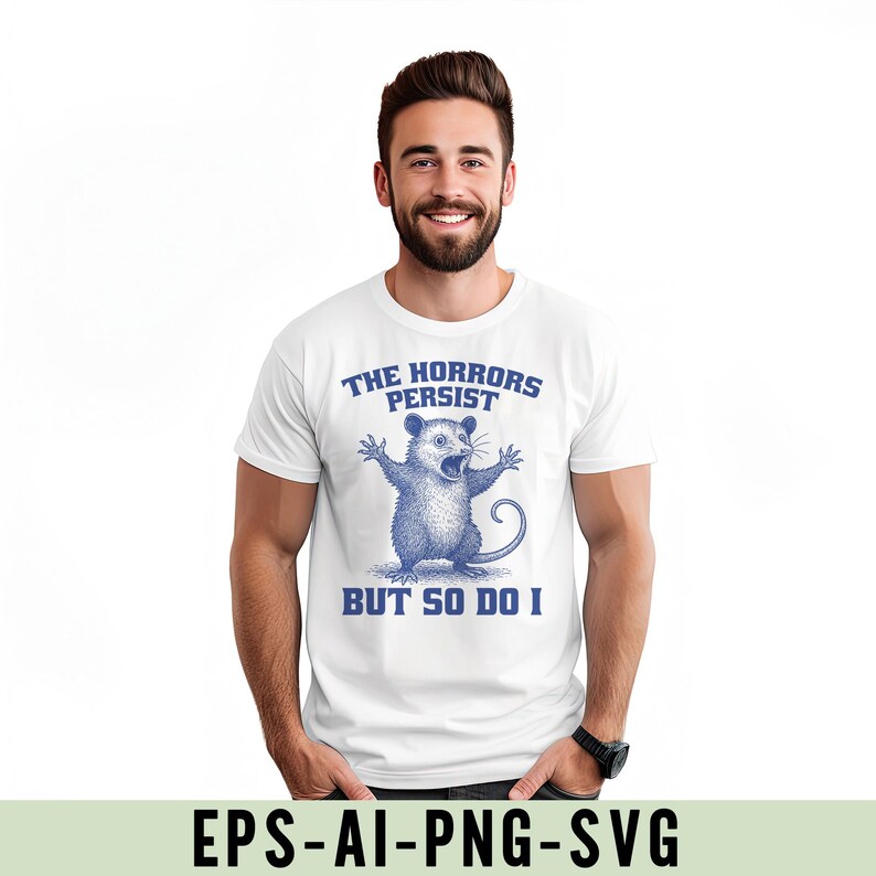 May include: White t-shirt featuring a blue opossum illustration and the text "THE HORRORS PERSIST BUT SO DO I". The shirt is worn by a person.