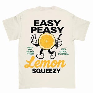 May include: A white t-shirt with a graphic of a cartoon lemon holding a straw. The text on the shirt reads "Easy Peasy Lemon Squeezy" and "Take it easy, squeeze it hard".  The text also reads "100% Citrus, 0% Drama".