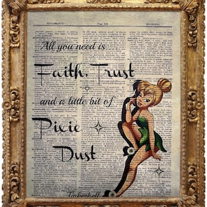 Puede incluir: Obra de arte enmarcada con un fondo de página de diccionario antiguo. El texto dice: "Todo lo que necesitas es Fe, Confianza y un poco de Polvo de Hadas". Un hada de dibujos animados con un vestido verde está a la derecha. El marco es dorado.