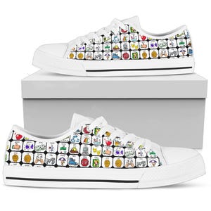 May include: White canvas sneakers with a black sole and white laces. The shoes are covered in a pattern of colorful, square illustrations. Each square contains a different image, including an apple, a stop sign, and musical notes.