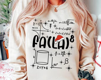 May include: Beige sweatshirt with the text "FA(LA)8" in black, a Santa hat, and mathematical equations. The design includes geometric shapes, formulas, and the number 8. The sweatshirt is a festive, holiday-themed item.