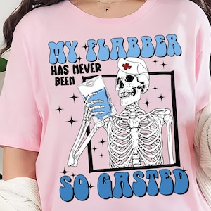 May include: Pink t-shirt with a graphic of a skeleton wearing a nurse's hat and holding an IV bag. The text on the shirt reads "My Flabber Has Never Been So Gasted".