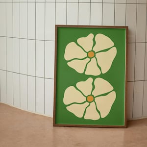 May include: A framed print with two stylized white flowers with yellow centers on a green background.