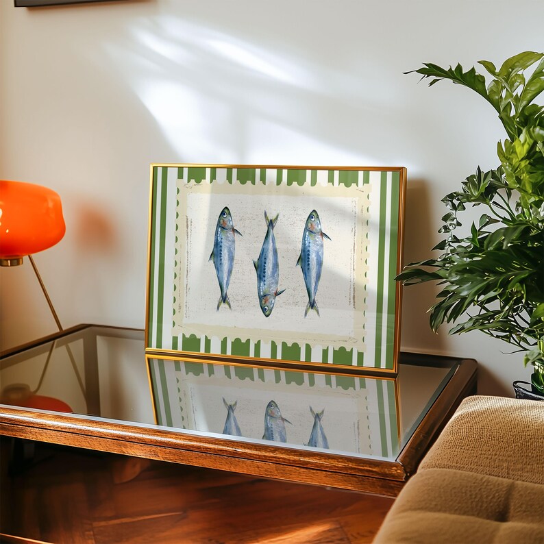 May include: A framed print with a green and white striped border. The print features three blue fish on a white background.