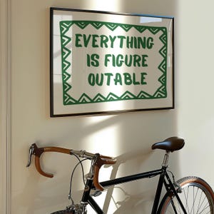 Pu&ograve; includere: Una stampa incorniciata con la scritta "EVERYTHING IS FIGURE OUTABLE" in verde. Sotto, una bicicletta nera con manubrio marrone e sella marrone. La bicicletta &egrave; montata su un muro bianco.