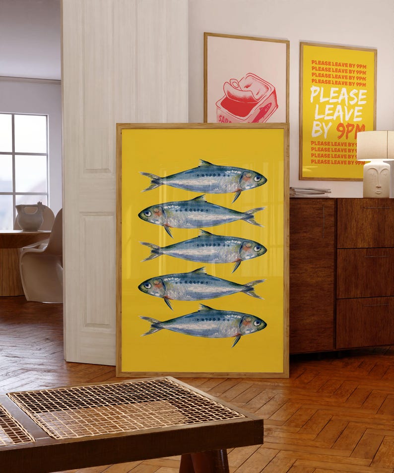 May include: A framed print with a yellow background and five blue and silver fish. The text "PLEASE LEAVE BY 9PM" is repeated multiple times in red and yellow on a white background in a separate frame.