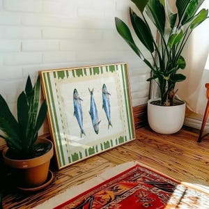 May include: A framed print with a green and white striped border. The print features three blue and silver fish with white outlines. The fish are arranged in a triangular pattern.
