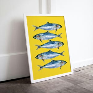 May include: A white framed print with a yellow background and five blue and silver fish arranged vertically in a row.