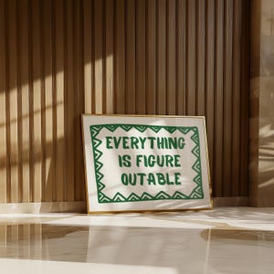 Pu&ograve; includere: Una stampa artistica incorniciata con la scritta "EVERYTHING IS FIGURE OUTABLE" in verde. L'opera d'arte ha uno sfondo bianco con un bordo verde ed &egrave; incorniciata in oro. La stampa &egrave; esposta contro un muro di legno.