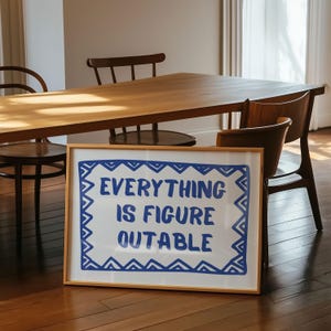 May include: A framed print with a white background and a blue border. The print features the text "EVERYTHING IS FIGURE OUTABLE" in blue lettering.