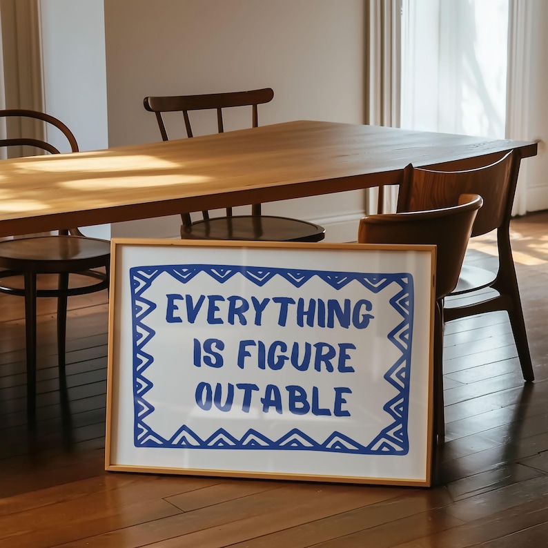 May include: A framed print with a white background and a blue border. The print features the text "EVERYTHING IS FIGURE OUTABLE" in blue lettering.