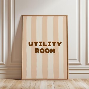 Peut inclure: Tableau encadré avec un motif à rayures verticales beiges et crème. Les mots "UTILITY ROOM" sont imprimés en marron. Le cadre est de couleur marron clair. Idéal pour la décoration intérieure.