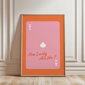 Póster físico - Póster del As de Corazones - Cita divertida: ¡Qué suerte tenemos! Carta de juego naranja y rosa UNO. Impresión artística.