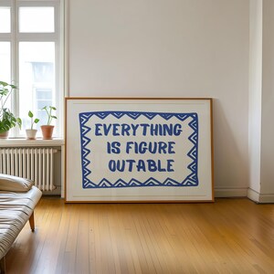 May include: A framed print with a white background and a blue border. The text "EVERYTHING IS FIGURE OUTABLE" is written in blue within the border.