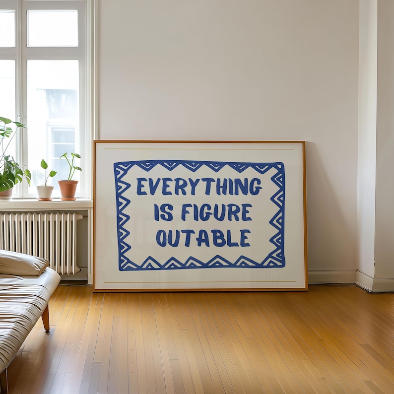 May include: A framed print with a white background and a blue border. The text "EVERYTHING IS FIGURE OUTABLE" is written in blue within the border.